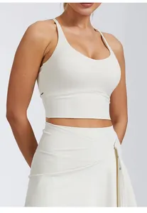 Vue détaillée d'une brassière de yoga crème avec dos croisé et jupe de sport assortie