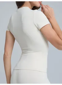 Vista posteriore di un top da yoga bianco a maniche corte che mostra la vestibilità slim