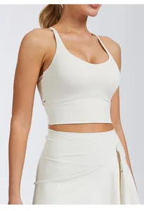 Vue détaillée d'une brassière de sport blanche élégante avec une jupe de yoga croisée assortie.