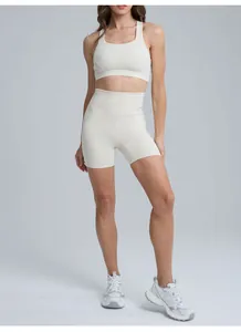 Detailed view of a cream high-waist yoga shorts and sports bra set on a fitness model.