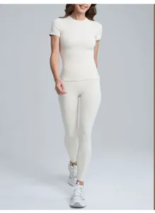 Vista dettagliata di un set da yoga da donna con top a maniche corte color crema