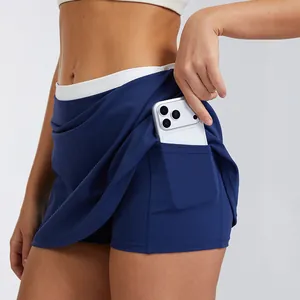 High-waisted navy tennis skort with white ribbed waistband and side phone pocket.