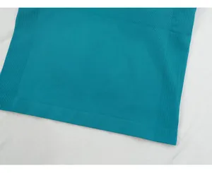 Close-up detail of teal seamless yoga vest showing ribbed hem and breathable fabric texture