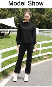 Modelo femenina al aire libre con un traje de sauna negro con capucha para entrenamiento