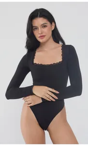 Macro detail view of the elegant square neckline with lace trim on a black bodysuit