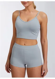 Detailweergave van lichtgrijze sneldrogende sportbeha en korte broek met hoge taille en zakken