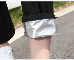 Detalle del forro térmico plateado con gotas de agua en un traje de sauna negro