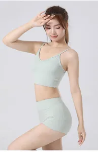 Detailweergave van een muntgroene yogaset met een smalle camisole top en korte broek met zakken