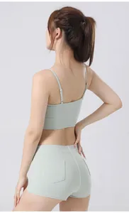 Achteraanzicht van een lichtgroene yogaset met sportbeha en korte broek met zakken