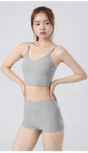Tweedelige grijze yogaset met sneldrogende sportbeha en korte broek met zijzakken