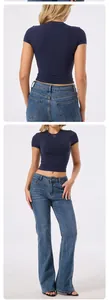 Detail view of a navy blue tight-fit yoga T-shirt paired with denim flare jeans.