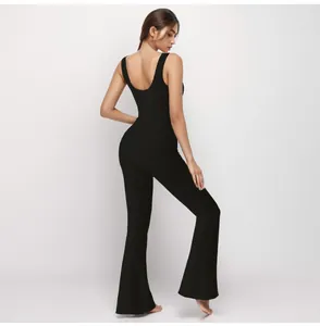 Back view of black ribbed one-piece yoga jumpsuit with U-neck and flared pants.