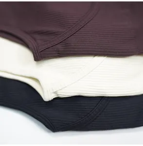 Macro view of ribbed fabric texture on burgundy, cream, and black yoga jumpsuits.