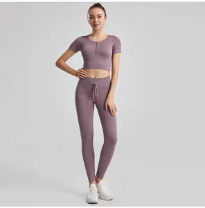 Full view of women's purple ribbed yoga set featuring drawstring leggings and zip-up crop top
