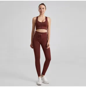 Detail view of women's ribbed maroon yoga set with drawstring leggings and zip-front bra