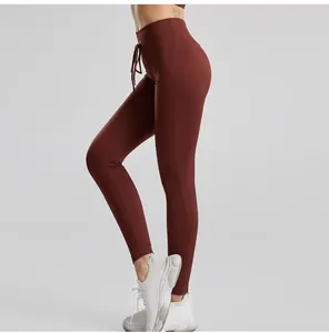Dettaglio di pantaloni yoga a costine a vita alta con cordoncino in marrone scuro.