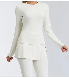 Close-up view of a cream long sleeve yoga top and leggings set with skirt overlay