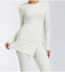 Close-up of cream long-sleeve yoga top and high-waist leggings with skirt detail.