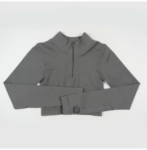 Detailed view of the ribbed fabric and thumbhole design on a grey yoga sports top.