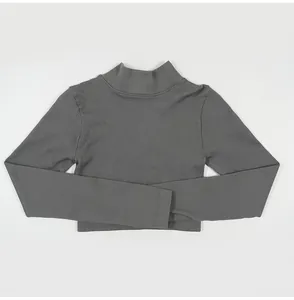 Detail view of a grey ribbed long sleeve mock neck crop top showing the soft knit texture