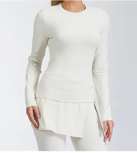 Detail shot of a cream-colored long-sleeve yoga top and matching high-waisted leggings.