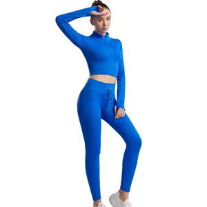 Two-piece blue ribbed yoga set featuring long sleeve zipper top and drawstring leggings