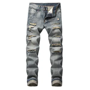 Dettaglio delle parti strappate su jeans in denim blu slim fit strappati dritti da uomo
