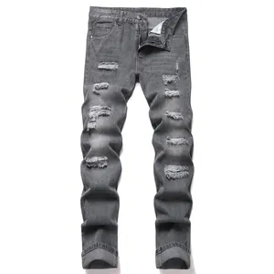 Dettaglio dei jeans in denim grigio slim fit con molteplici strappi sulle ginocchia