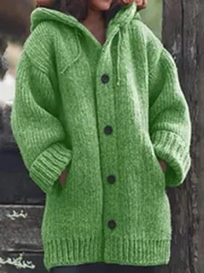 Detailed macro view of a green chunky knit hooded cardigan featuring big black buttons