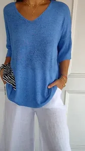 Detail view of blue V-neck knit sweater with casual linen-like texture on model