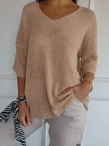 Detail view of a women's casual V-neck lightweight knit sweater in beige styled with jewelry