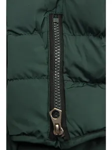 Close-up detail of the heavy-duty zipper on a warm dark green quilted winter coat