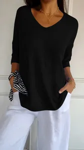 Close-up detail of a minimalist black V-neck short-sleeved knitted top for women
