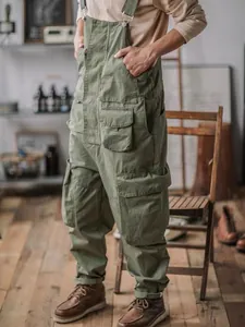 Retro olive green men's cargo overalls with multi-pocket design in a vintage studio