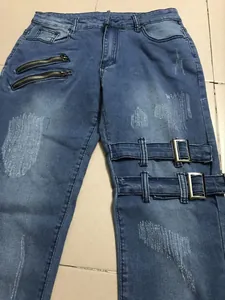 Detalle de vaqueros azules slim para hombre con cremalleras decorativas y hebillas de metal.