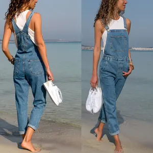 Front and back view of stylish women's slim blue denim overalls on a sunny beach