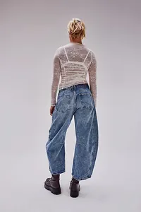 Rear view of trendy loose wide-leg washed denim jeans for women in a studio setting
