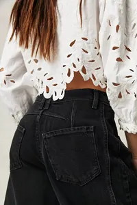 Detail view of high-waisted washed black wide-leg denim jeans showing back pocket