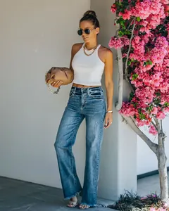 Volledige weergave van flared jeans met hoge taille en een witte geribbelde haltertop.