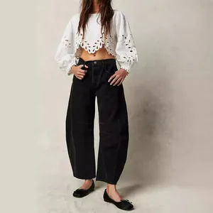 Women's loose wide leg washed black denim jeans in a full body studio fashion photo
