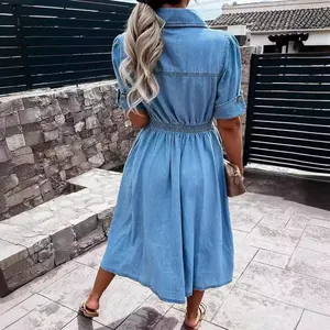 Back view of a chic light blue denim shirt dress with short sleeves and pleated skirt.