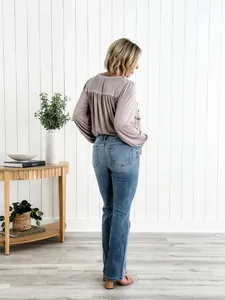 Vue arrière complète d'un jean évasé bleu élégant à taille haute sur mannequin