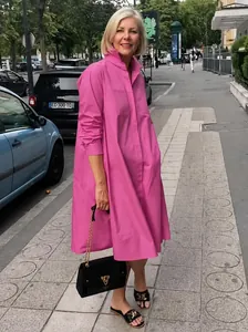 Full body shot of a pink cotton linen shirt dress worn by a model in a street setting