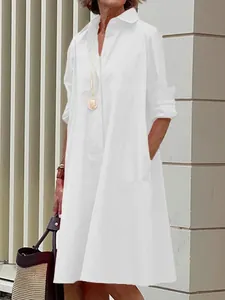 A full view of an elegant white cotton linen button-down midi shirt dress on a model