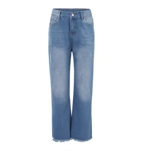 Dettaglio dei jeans azzurri lavati da donna con taglio micro-flare e bordo sfrangiato.