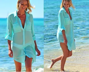 Detail of turquoise crinkle fabric beach cover-up shirt with front pockets and buttons