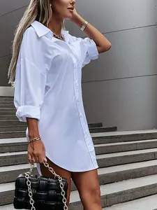 Detailed side view of a white oversized cotton button-down shirt dress for women.