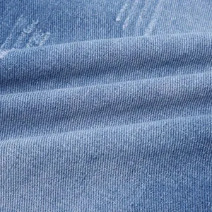 Macro dettaglio del tessuto denim lavato azzurro che mostra trama e consistenza