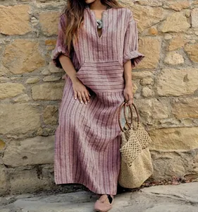 Détail d'une robe longue en coton et lin à rayures amples avec une poche sur le devant