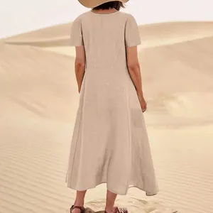 Back view of a beige cotton linen midi dress in a desert setting during summer